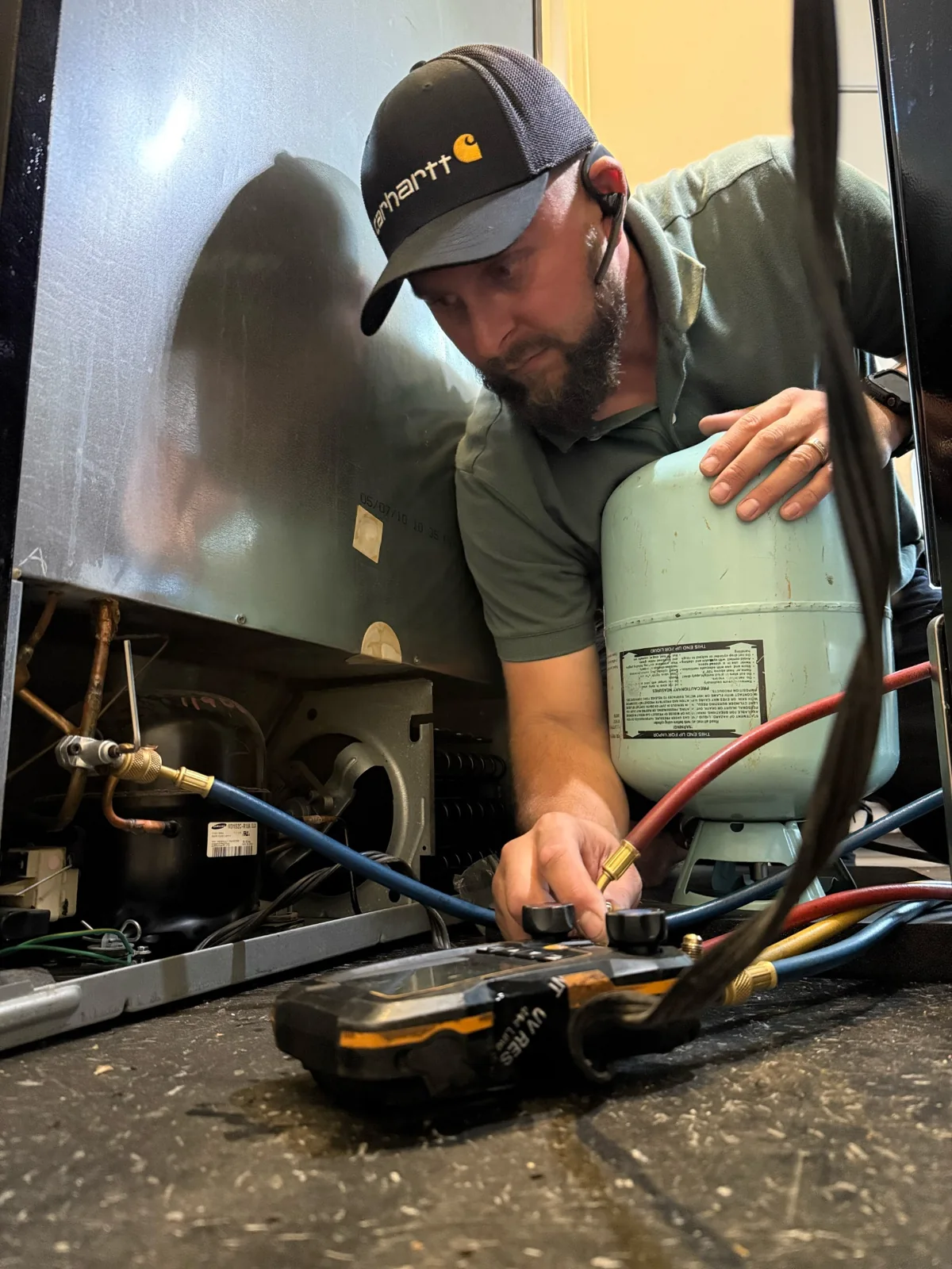 Technician checking a refrigeration system with gauges
